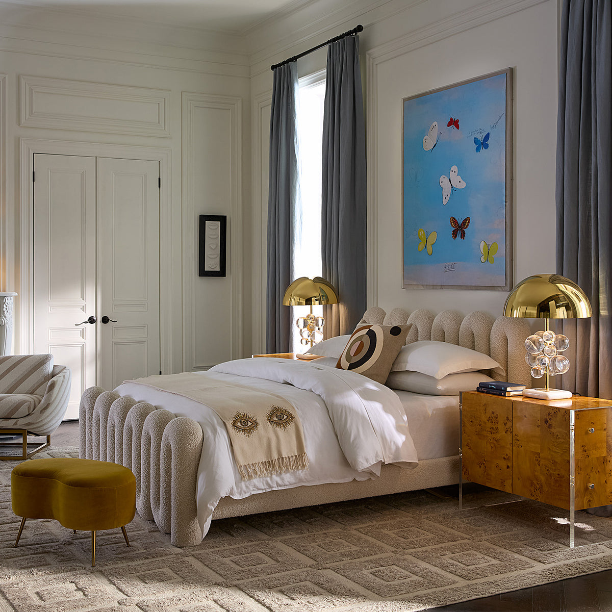 Neatly made bed in a bedroom with decorative pillows and artwork on the wall.