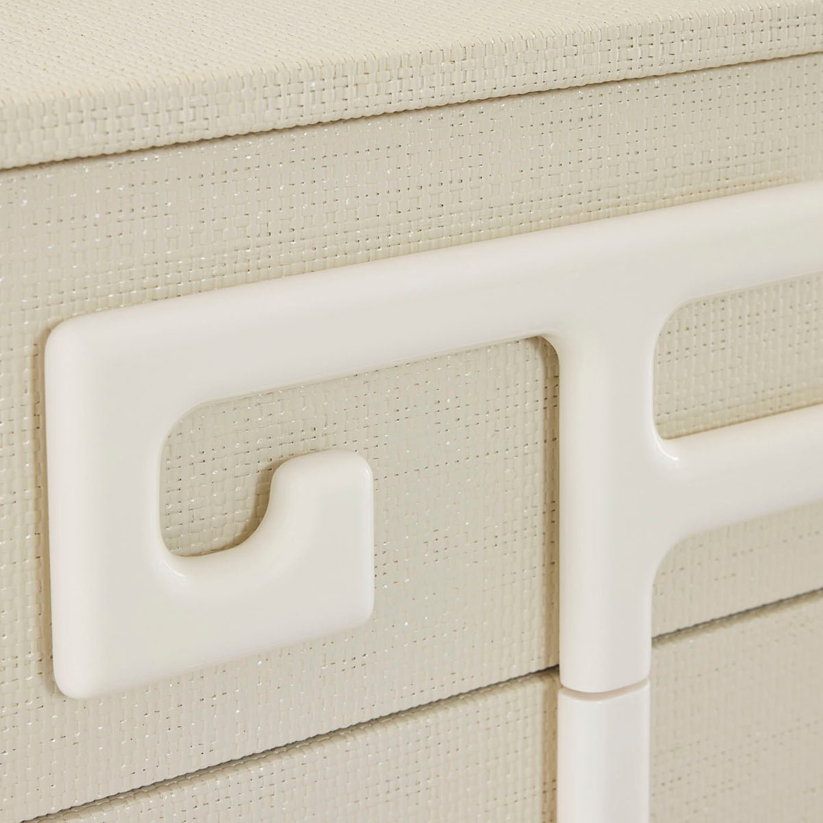 Close-up of a beige textured surface with a white handle and trim.
