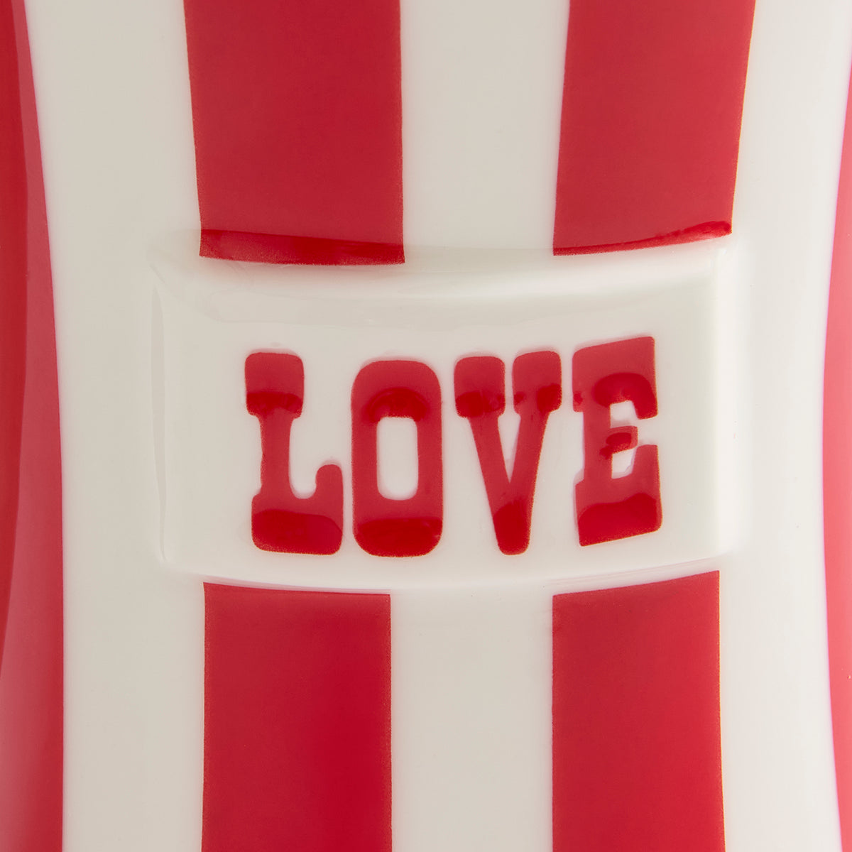 Close-up of a red and white striped product with the word "LOVE" in red raised lettering across the center.