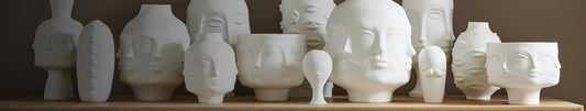 White vases with different face-like surface designs