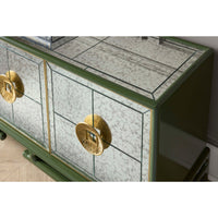 Green dresser with gold handles on a light wood floor.