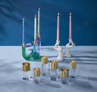 Collection of colorful candle holders and candles on a blue background