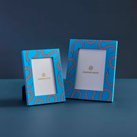 Two blue photo frames with decorative patterns on a dark blue background