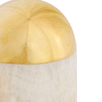 Decorative object with gold top and white base on a white background