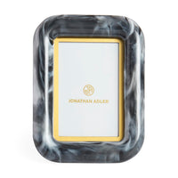 Marble-patterned picture frame with gold border and 'Jonathan Adler' logo on a white background