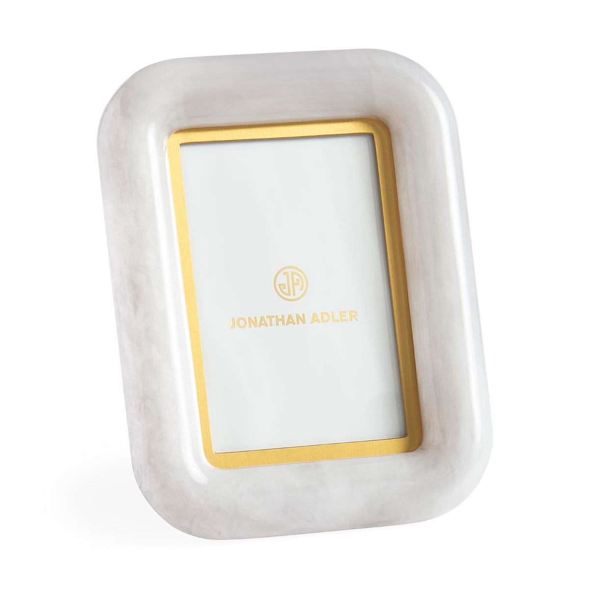 White and gold rectangular jewelry dish with 'Jonathan Adler' branding on a white background