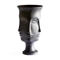A sculptural black ceramic vase shaped like a stylized female face, photographed against a solid white background.