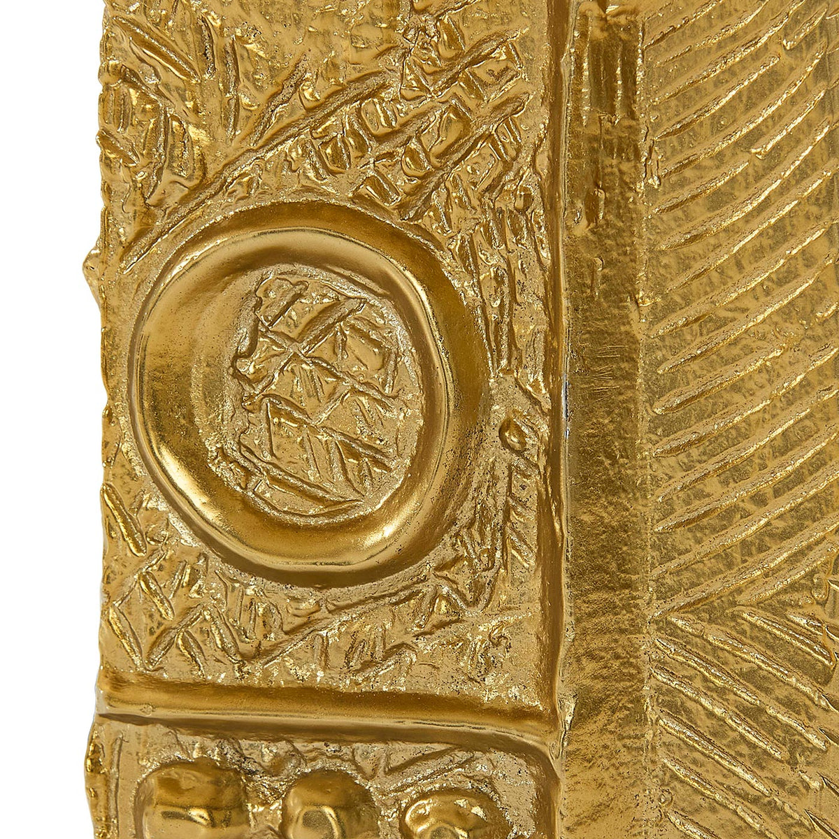 Gold artifact with intricate designs and a central emblem on a white background