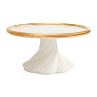 A round pedestal table featuring a glossy white sculptural base and a polished gold metal rim around a clear glass top, shown on a solid white background.