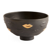Black bowl with gold lips design on a white background