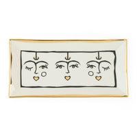 Rectangular ceramic tray with abstract face design on a white background
