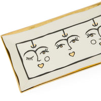 Decorative tray with abstract face designs and gold accents on a white background