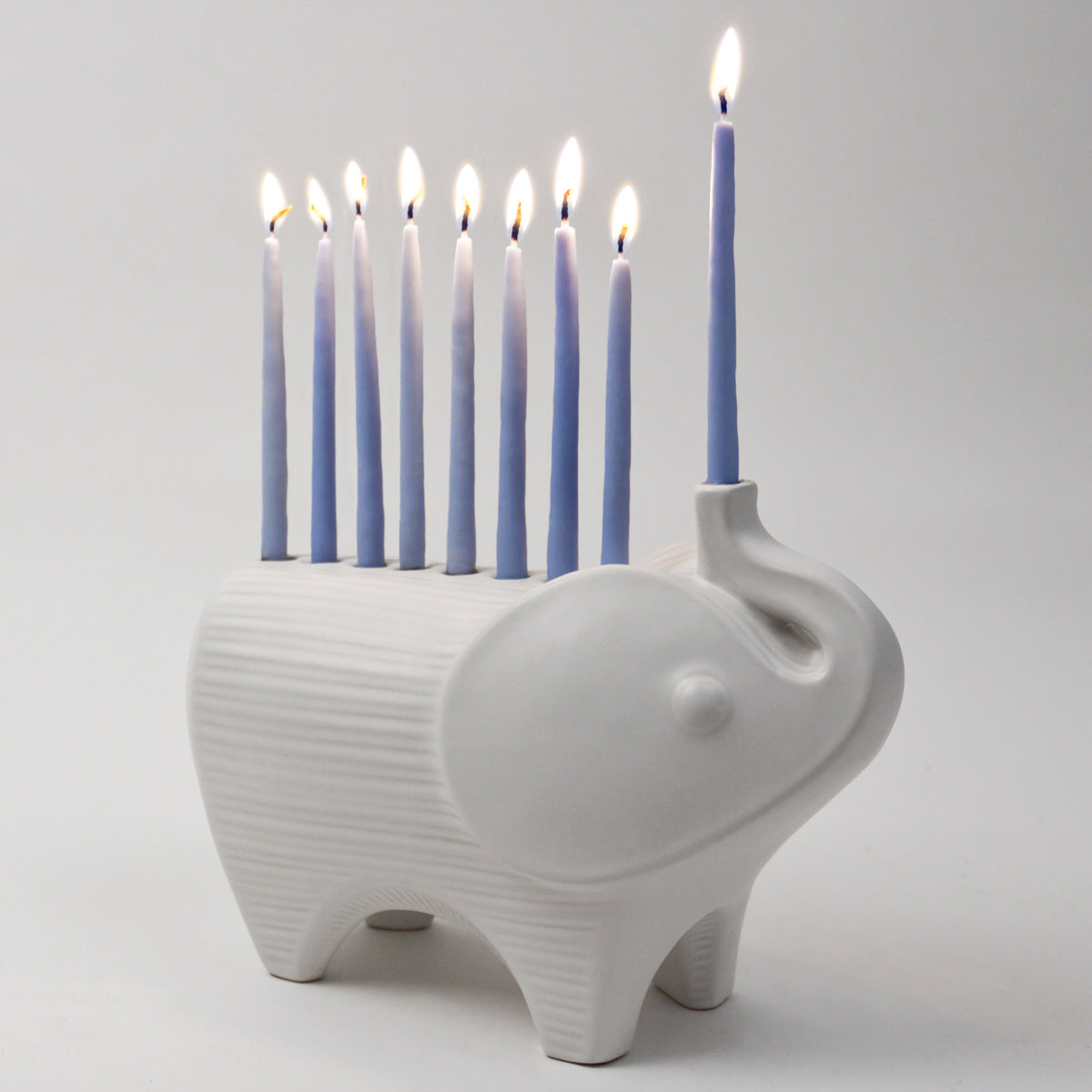 ceramic elephant menorah white with blue candles - angle view