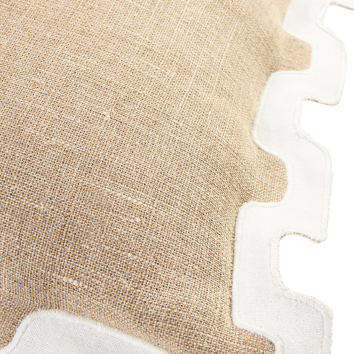 Close-up of a beige woven textile with a white scalloped border on a white background.
