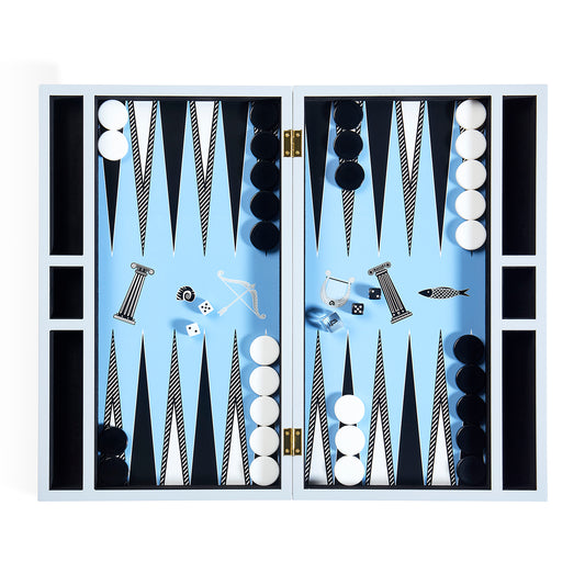 A fully set up backgamol with a light blue playing field, black and white checkers, and various game pieces arranged symmetrically inside an open white wooden case.