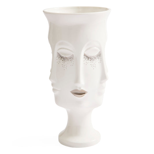 A white ceramic vase sculpted in the shape of a stylized female face with closed eyes and delicate silver glitter accents around the eyes, set against a plain white background.