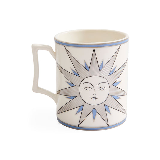 A white ceramic mug featuring a stylized sun face design with gray rays and blue accents, set against a plain white background.