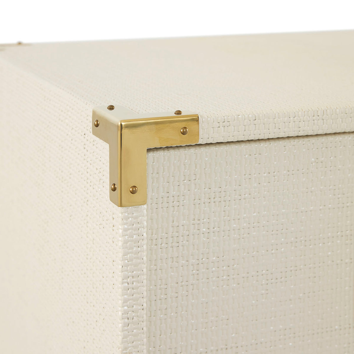 Close-up of a gold bracket on a textured white surface