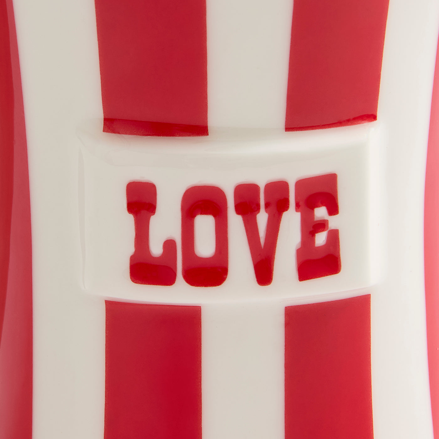 Close-up of a red and white striped product with the word "LOVE" in red raised lettering across the center.
