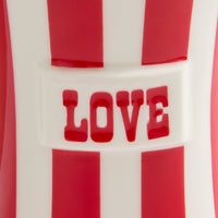 Close-up of a red and white striped product with the word "LOVE" in red raised lettering across the center.